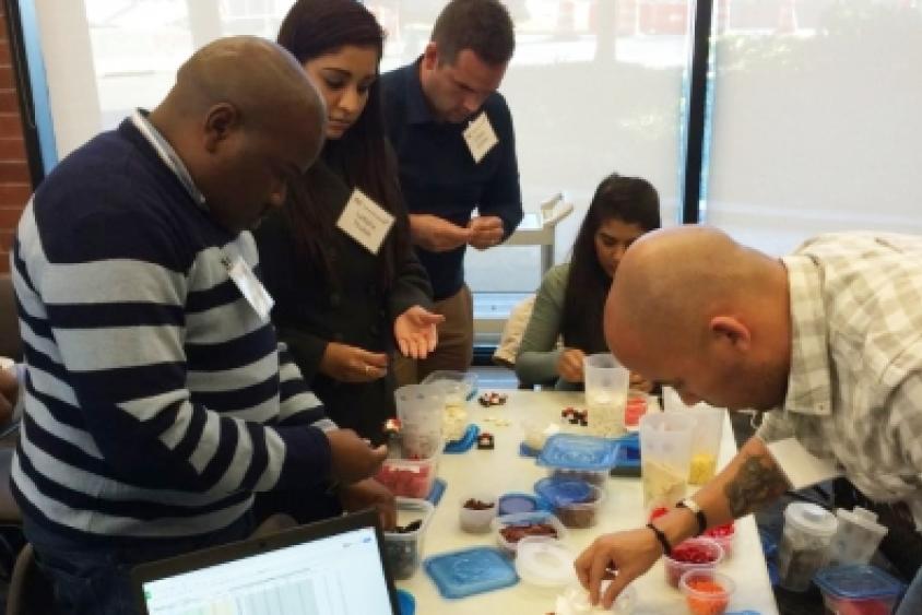 MIT Professional Education students from South Africa use Lego bricks in a manufacturing game to assemble small cars.